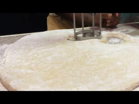 Students practice cutting doughnuts from the rolled out dough they had made previously.